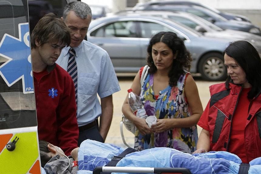 Ashya King, a 5-year-old British boy with a brain tumour, lies on a stretcher as he arrives with his parents Brett (second, left) and Naghemeh King (second, right) at the Proton Therapy Center in Prague on Sept 9, 2014.&nbsp;-- PHOTO: REUTERS