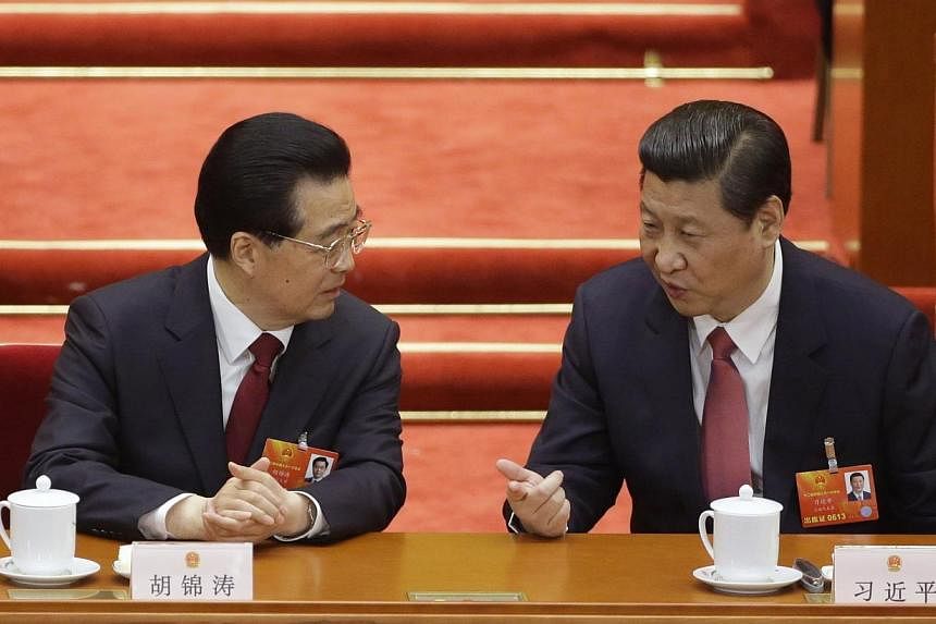 China's newly-elected President Xi Jinping (right) talks with China's former President Hu Jintao during the fourth plenary meeting of the National People's Congress (NPC) at the Great Hall of the People in Beijing on March 14, 2013.&nbsp;-- PHOTO: RE