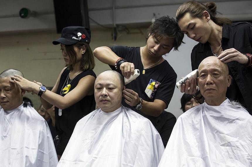 Founders of the Occupy Central civil disobedience movement (from left) academics Chan Kin-man and Benny Tai and Reverend Chu Yiu-ming shave their heads during a protest to call for people to join them for an upcoming "Occupy Central" movement rally i