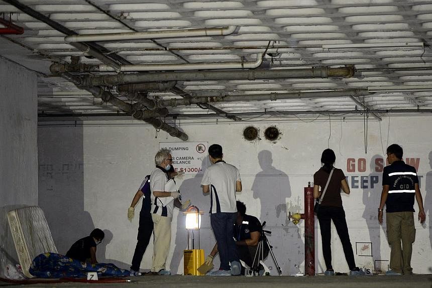 Forensic investigators at the scene where a male body was found at an abandoned carpark at the 11th floor at Pearls Centre. -- ST PHOTO:&nbsp;DESMOND LIM