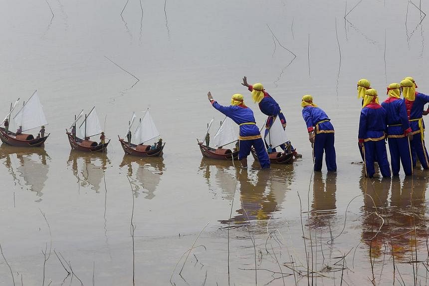 Vietnamese fishermen from Ly Son island release miniature fishing boats with artificial soldiers during a re-enactment of the Khao Le The Linh ceremony at Dong Mo, outside Hanoi, on June 29, 2014.&nbsp;Hanoi has accused Chinese sailors of attacking a