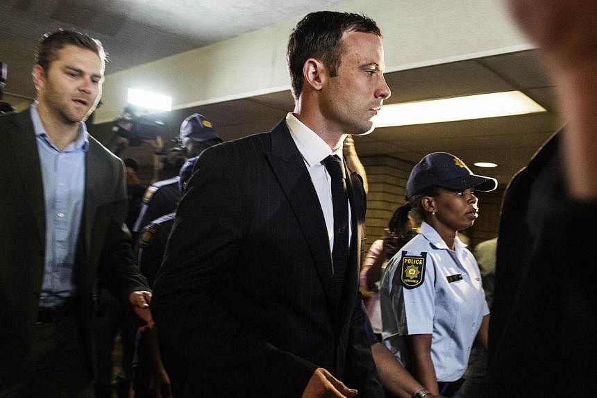 "Blade Runner" Oscar Pistorius (centre) arrived in court on Thursday to face judgment over the death of his glamorous lover, with the Paralympian facing a possible life sentence if found guilty of murder. -- PHOTO: AFP