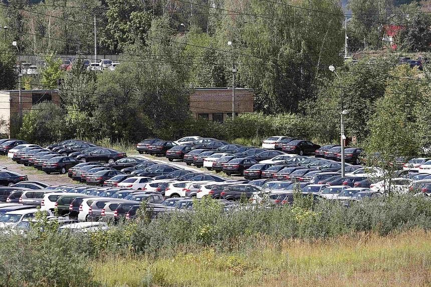 Cars, produced by foreign automobile-makers, are seen at a parking of a dealership on the outskirts of Moscow on Aug 18, 2014. -- PHOTO: REUTERS