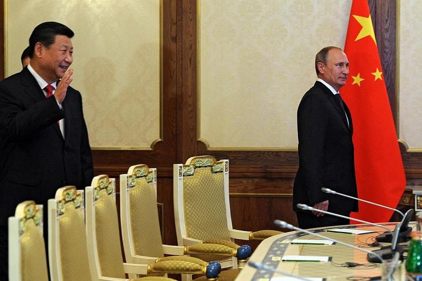 Russian President Vladimir Putin (right) and Chinese President Xi Jinping (left) attend a meeting in Dushanbe on September 11, 2014. -- PHOTO: AFP