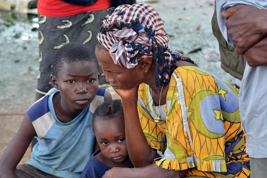 A woman and her kids mourn the death of a family member on Sept 10, 2014 in a district of Monrovia. -- PHOTO: AFP