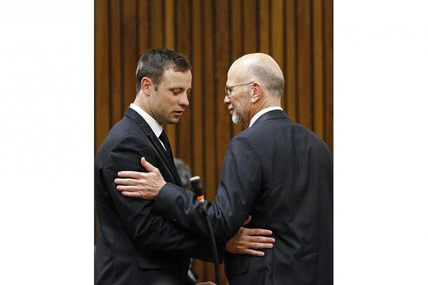 Olympic and Paralympic track star Oscar Pistorius (left) chats with his uncle Arnold ahead of the verdict in his trial at the high court in Pretoria on Sept 12, 2014. -- PHOTO: REUTERS