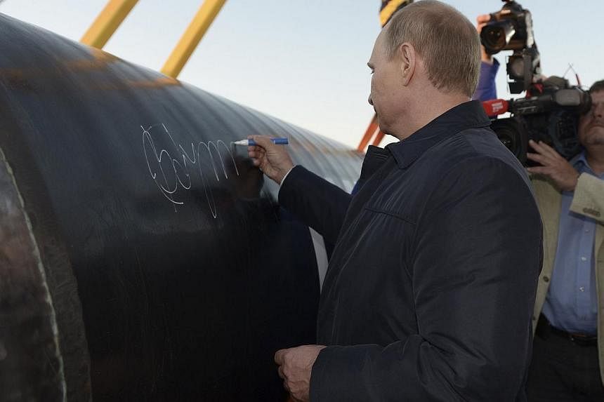 Russia's President Vladimir Putin signs on the first segment of pipeline during a ceremony marking the start of construction of "Power of Siberia" pipeline at the village of Us Khatyn on Sept 1, 2014. -- PHOTO: REUTERS