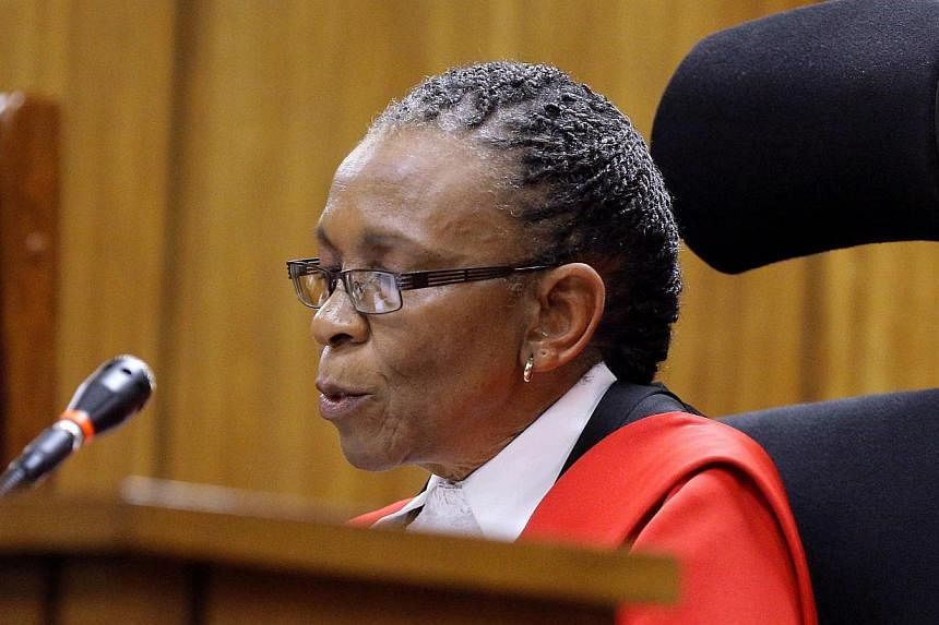 Pistorius fired four shots into a toilet cubicle killing Ms Reeva Steenkamp (both seen here in a 2012 photo). Judge Masipa (below) described Pistorius' conduct as "negligent".