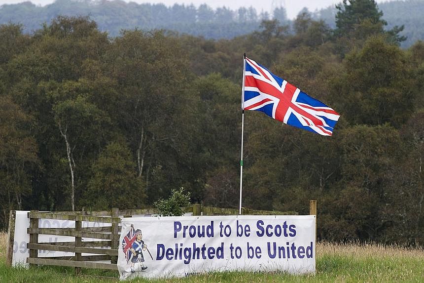 A pro-union banner and the British Union flag are pictured in a field near the Scottish borders on Sept 11, 2014. -- PHOTO: AFP