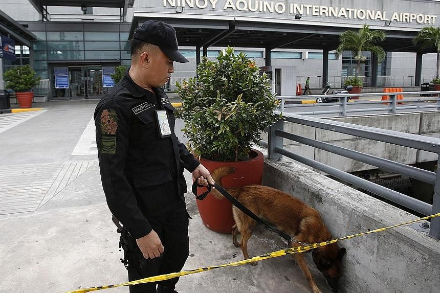 An airport police officer and a sniffer dog patroling Terminal 3 of the Ninoy Aquino International airport in Pasay City, Metro Manila on Sept 1, 2014. Airport security was heightened after four people were arrested after a vehicle containing a bomb 