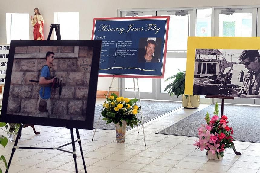 Pictures stand at Our Lady of the Rosary Church for a special mass in remembrance of journalist James Foley Aug 24, 2014 in Rochester, New Hampshire. -- PHOTO: AFP