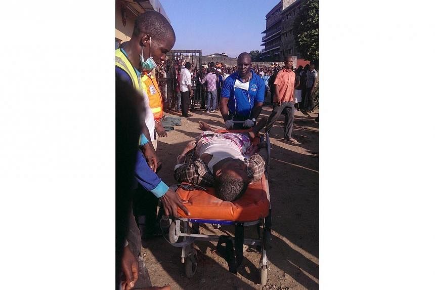 A handout photo taken and released by Nigeria's National Emergency Management Agency (NEMA) on Sept 12, 2014 shows emergency workers transporting an injured man on a stretcher after he was pulled out from the rubble of the collapsed guest house of Th