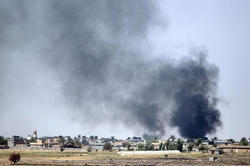 Smoke rises in the distance after Iraqi forces fired a mortar towards the village of Yakanja controlled by Islamic State in Iraq and Syria (ISIS) militants during heavy clashes near Tuz Khurmatu in Salaheddin province, about 88km south of Kirkuk, on 