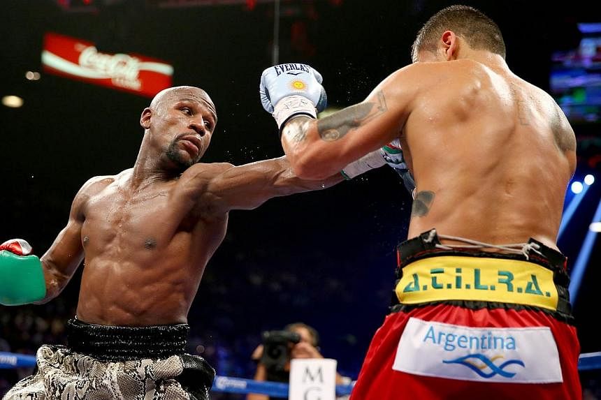 Champion boxer Floyd Mayweather ran his unbeaten streak to 47 straight fights by beating Argentine slugger Marcos Maidana by a unanimous decision in their 12-round rematch on Saturday, Sept 14, 2014. -- PHOTO: AFP