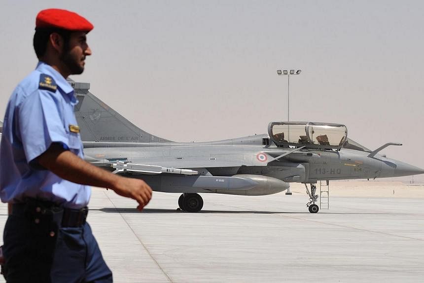 An Emirati soldier walks past a Rafale French jet fighter at a military base near Abu Dhabi on May 25, 2009.&nbsp;France has joined Britain in carrying out reconnaissance flights in support of the United States air campaign against jihadists launched