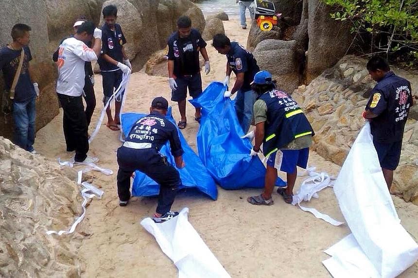 Thai workers carry the bodies of two British tourists on Koh Tao island in the Surat Thani province of southern Thailand on Sept 15, 2014.&nbsp;The tourists were found beaten to death on a beach in Thailand on Monday, the police said, sparking a murd