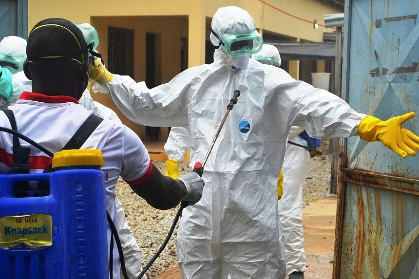 Guinea's Red Cross health workers prepare to carry the body of a victim of Ebola at an Ebola treatement centre near the hospital Donka in Conakry on Sept 14, 2014.&nbsp;Malaysia will send more than 20 million medical rubber gloves to five African nat