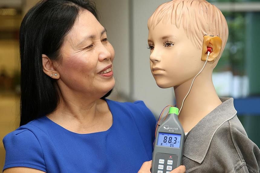 Changi General Hospital's senior tinnitus counseller Joyce Lim shows a sound mannequin which can help users measure the volume of their portable music players. -- ST PHOTO:&nbsp;SEAH KWANG PENG