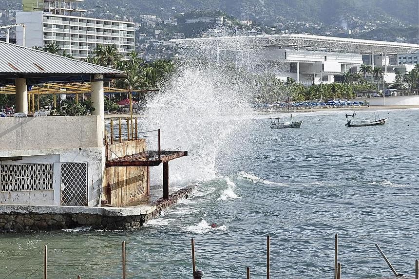 Waves pound the beach in Acapulco as Hurricane Odile churns far off shore. -- PHOTO: REUTERS