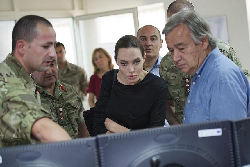 UN High Commissioner for Refugees (UNHCR) Antonio Guterres (right) and American actress and UNHCR Special Envoy Angelina Jolie (centre) visit the Armed Forces of Malta operations centre in Luqa, outside Valletta, in this handout picture taken on Sept