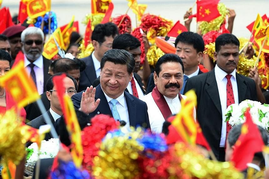 China's President Xi Jinping (centre) gestures as Sri Lankan President Mahinda Rajapakse (2nd right) looks on during a welcome ceremony at the Bandaranaike International Airport in Katunayake on Sept 16, 2014.&nbsp;China's President Xi Jinping held t