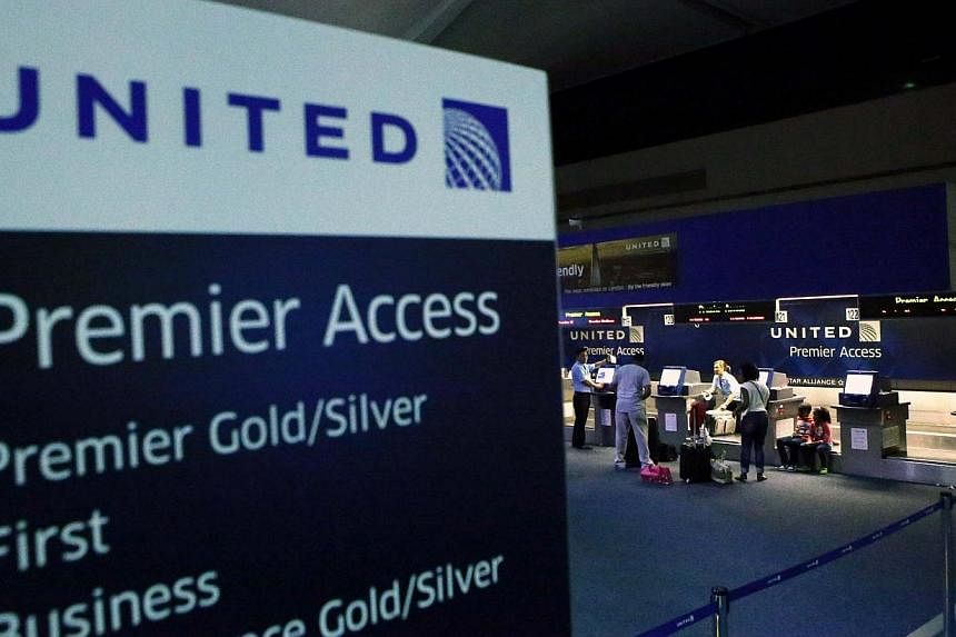 People are seen at the United Airlines terminal at Newark International Airport in New Jersey, on July 22, 2014.&nbsp;United Airlines and union officials said Monday that eligible flight attendants will be paid up to US$100,000 (S$125,000) to leave t