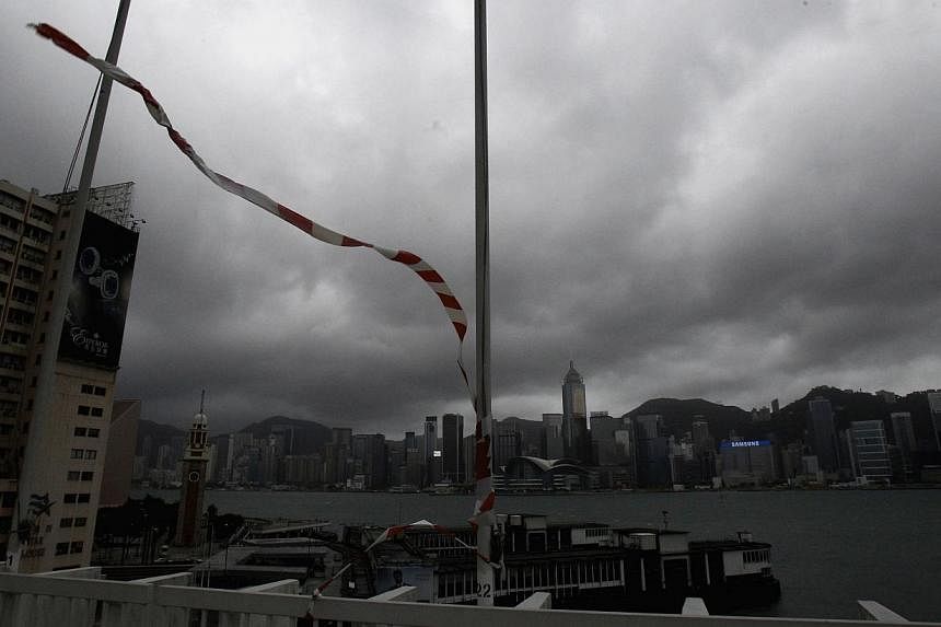 Construction tape whips about in strong winds at the Ocean Terminal, as dark clouds loom over Victoria Harbour and Hong Kong island in the background on Sept 16, 2014. -- PHOTO: REUTERS