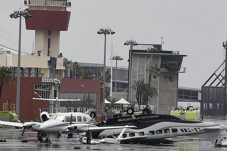 View of damaged aircrafts at the international airport of San Jose del Cabo, on Sept 15, 2014 after hurricane Odile knocked down trees and power lines in Mexico's Baja California peninsula. -- PHOTO: AFP
