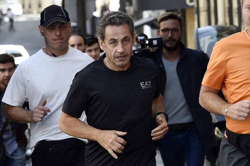 Former French president Nicolas Sarkozy (centre) jogs on Sept 16, 2014 in Paris.&nbsp;It's one of the worst kept secrets in French politics: Nicolas Sarkozy, who leapt to power in 2007 before suffering a humbling defeat five years later, is poised to