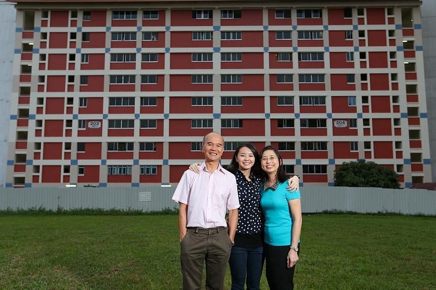 Ms Charlene Koh (centre), who proposed the terracotta colour scheme, stands in front of a painted block with parents Koh Kheng Joo, 60, and Kristine Koh, 59. -- ST PHOTOS: ONG WEE JIN