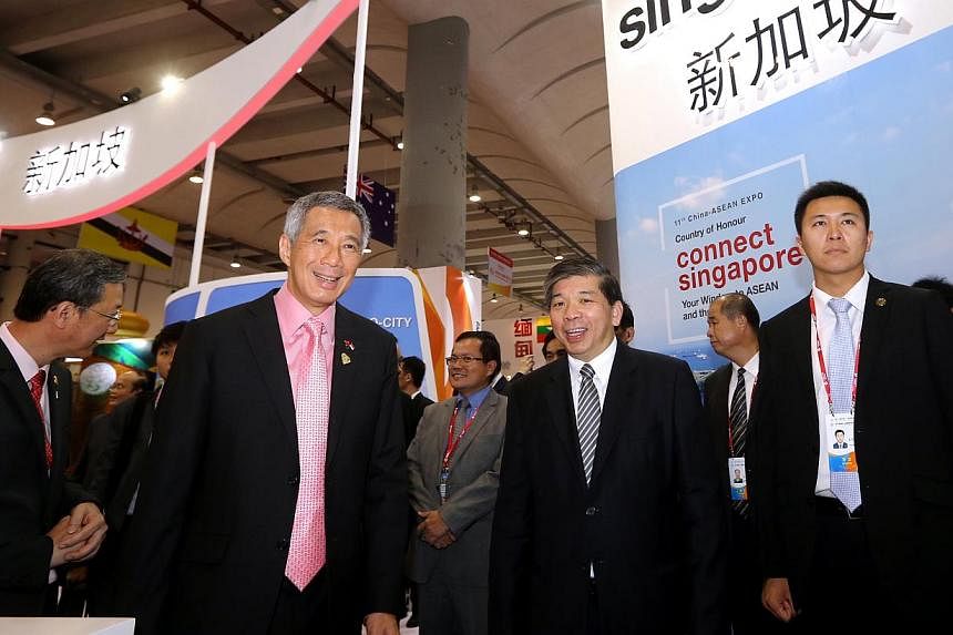 PM Lee Hsien Loong and Singapore Business Federation chairman Teo Siong Seng (second from right) touring the Singapore Pavilion at the 11th China-Asean Expo in Nanning yesterday.