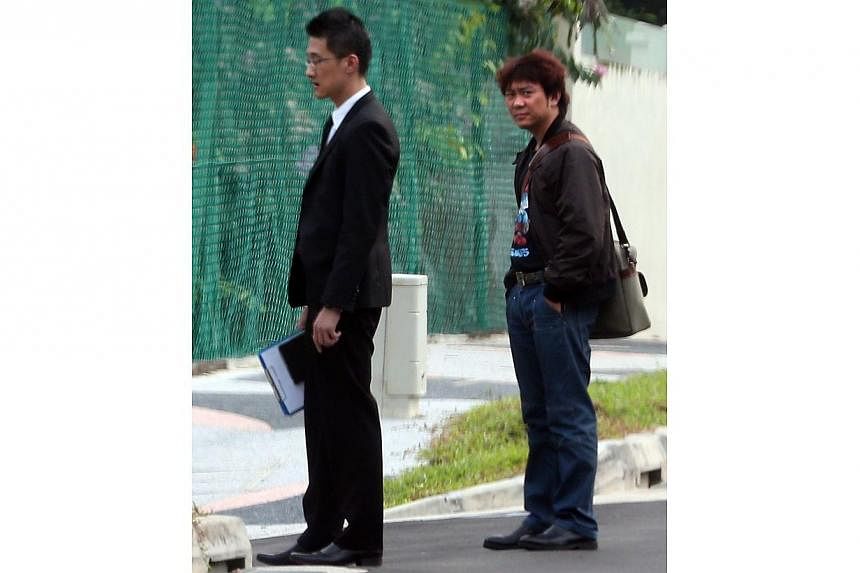 Former China tour guide Yang Yin (right) and his lawyer (left) outside the bungalow of 87-year-old widow Madam Chung Khin Chun. -- ST PHOTO: NEO XIAOBIN