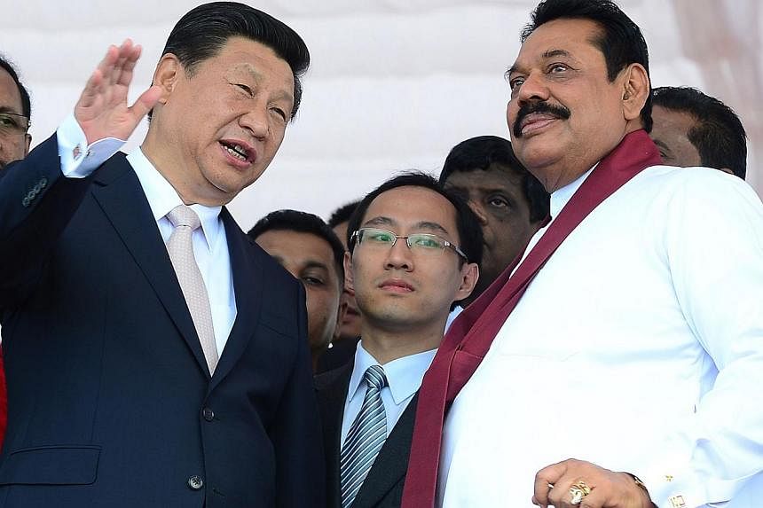 Chinese President Xi Jinping (left) speaks with Sri Lankan President Mahinda Rajapakse (right) as he formally launched the construction of a Chinese-funded US$1.4 billion (S$1.77 billion)&nbsp;port city on the last day of his visit to Sri Lanka in Co