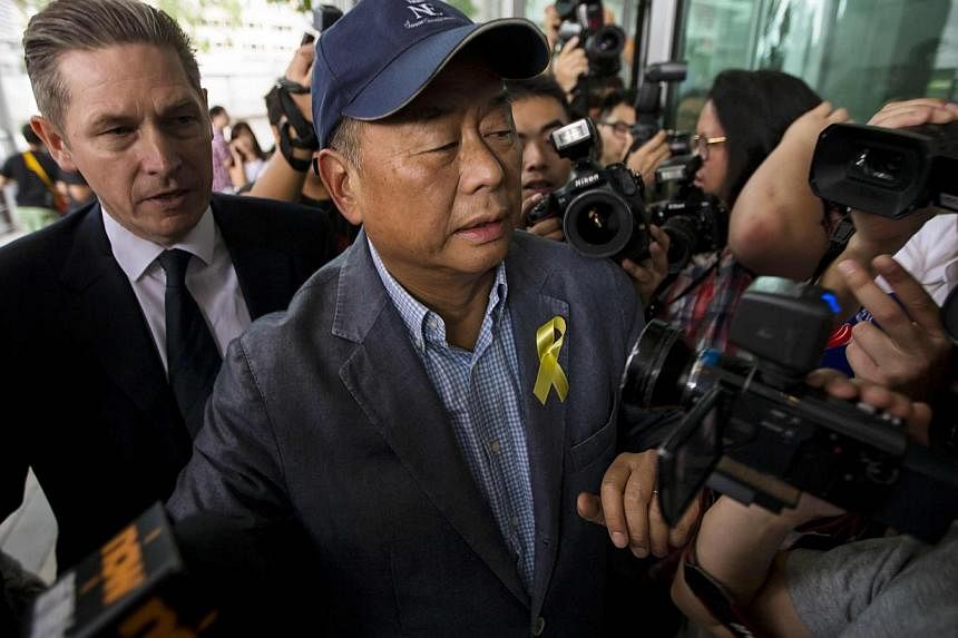 Jimmy Lai (right), owner of Hong Kong-based media company Next Media Ltd, arrives at the Independent Commission Against Corruption (ICAC) headquarters in Hong Kong on Sept 17, 2014. -- PHOTO: REUTERS