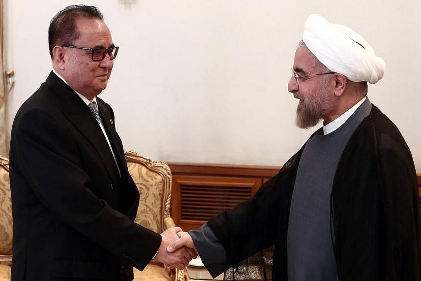 Iranian President Hassan Rouhani (right) shakes hands with North Korea's Foreign Minister Ri Su Yong (left) during a meeting in Teheran on Sept 16, 2014. -- PHOTO: AFP&nbsp;