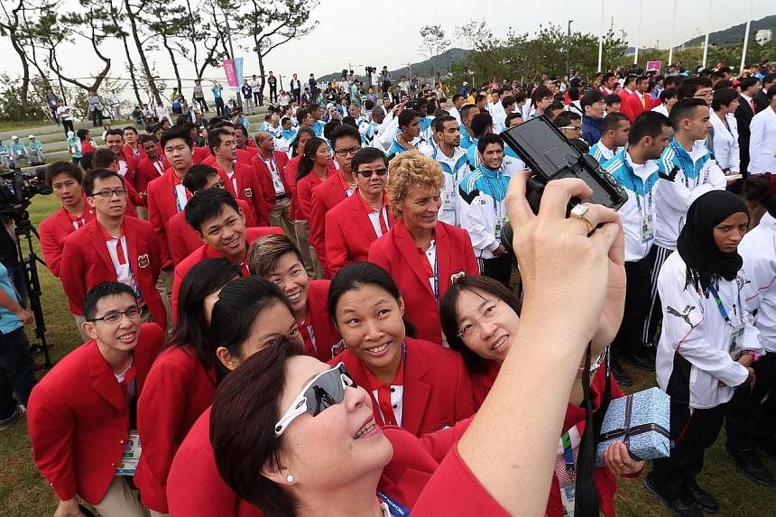 Singapore's chef de mission Jessie Phua (wearing sunglasses) takes a selfie with the athletes and officials after they arrive at the Flag Plaza for the team welcome ceremony at Incheon, South Korea on Sept 18, 2014. -- ST PHOTO: NEO XIAOBIN