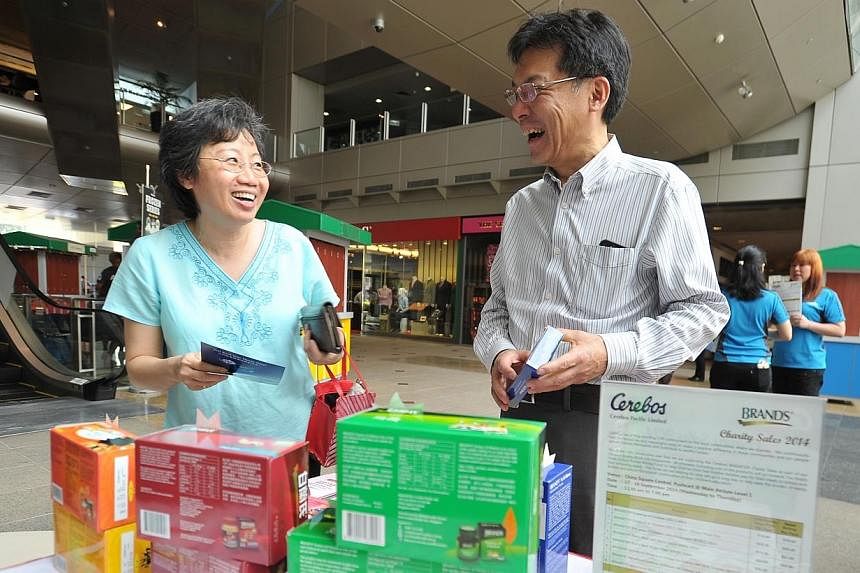 A customer with Cerebos chief executive officer, Mr Gen Saito, at the company's annual charity sale booth at China Square Central on Sept 17, 2014. -- PHOTO: LIM YAOHUI FOR THE STRAITS TIMES&nbsp;