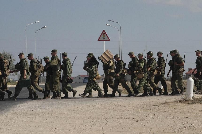 Russian marines cross a road in the Crimean port of Sevastopol, Sept 17, 2014.&nbsp;The government in Kiev said Thursday that Russia had massed around 4,000 troops stationed in annexed Crimea on the border with Ukraine. -- PHOTO: REUTERS