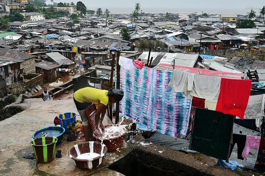 A woman washes clothes in the Kroo town slum in Freetown on Aug 13, 2014.&nbsp;Sierra Leone prepared Thursday for an unprecedented three-day nationwide lockdown to contain the deadly spread of the Ebola virus in a controversial move which experts cla