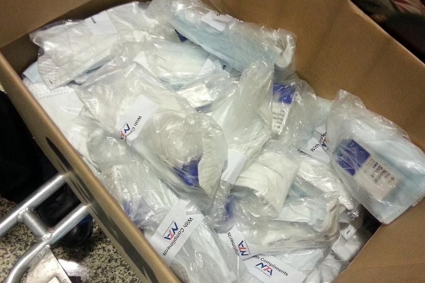 The National Taxi Association (NTA) distributed a care package, which includes one N95 mask, two surgical masks and a bottle of eyedrops, to some 1,000 taxi drivers at Changi Airport on Thursday afternoon. -- ST PHOTO: AUDREY TAN