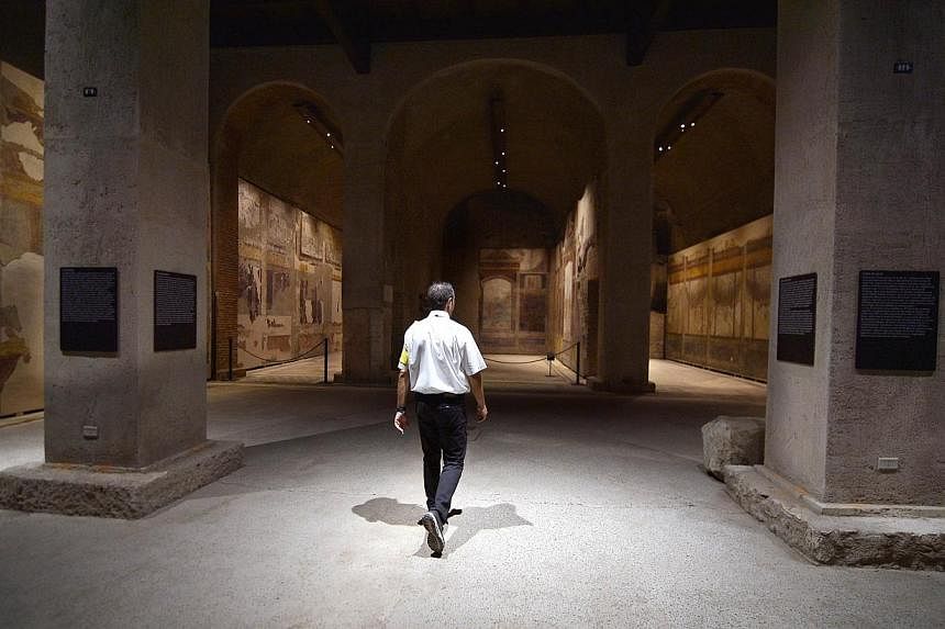 A security man walks inside a room at the House of Augustus on the Palatine hill in Rome on Sept 17, 2014.&nbsp;Lavishly frescoed rooms in the houses of the Roman Emperor Augustus and his wife Livia are opening for the first time to the public Thursd