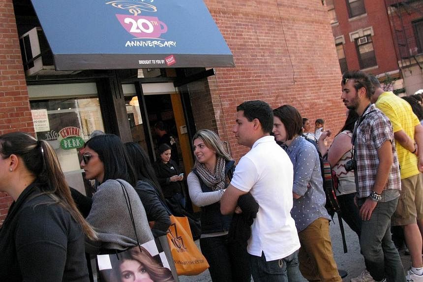 Tourists line up outside a temporary "pop up" reproduction of the "Central Perk" coffee shop, a center piece set of the television situation comedy "Friends" in New York on Sept 17, 2014. Obsessed "Friends" fans on Wednesday mobbed a pop-up replica o
