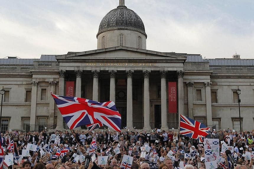 Pro-union supporters, opposing Scottish independence from the United Kingdom wave flags during a rally in Trafalgar Square in London on Sept 15, 2014, ahead of the Scottish independence referendum. -- PHOTO: AFP