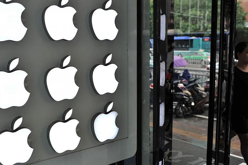 A woman walks past an Apple store in Hefei, east China's Anhui province, on Sept 10, 2014. -- PHOTO: AFP