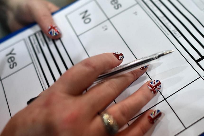A count observer with Union flag finger nails looks on as ballot papers are counted in the Aberdeen Exhibition and Conference Centre in Aberdeen, on Sept 18, 2014, immediately after the polls close in the referendum on Scotland's independence. -- PHO