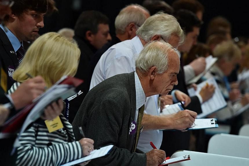 Count observers look on as ballot papers are counted in the Aberdeen Exhibition and Conference Centre in Aberdeen. Scotland looks likely to have voted “no” in a historic referendum on separation from the rest of the United Kingdom. -- PHOTO: AFP