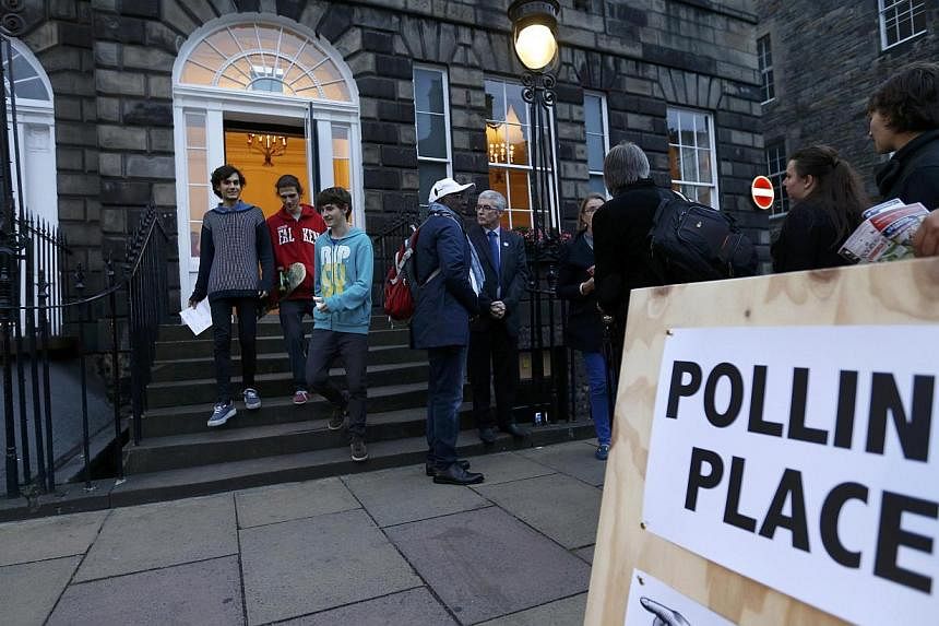 Young voters leave a polling station in Charlotte Square, Edinburgh, Scotland, on Sept 18, 2014. -- PHOTO: REUTERS