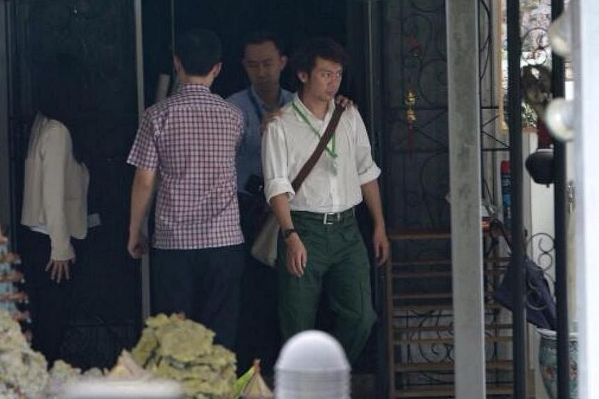 Former tour guide Yang Yin leaving the house at Gerald Crescent on Sept 19, 2014. He was brought back to the cantonment police complex. -- ST PHOTO: NG SOR LUAN