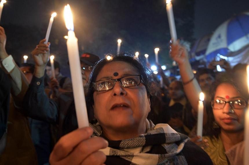 In this photograph taken on January 2, 2014, Indian activists hold candles as they participate in a vigil to protest against the gang-rape and murder of a teenager in Kolkata. A court in eastern India on September 19, 2014 sentenced five men to 20 ye