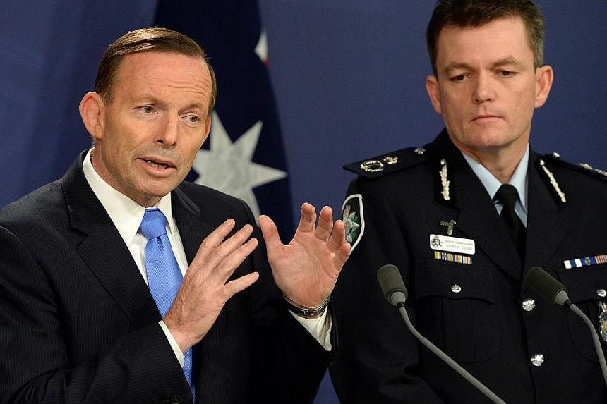 Australia's Prime Minister Tony Abbott (left) speaks at a joint press conference with Australian Federal Police Commissioner Andrew Colvin (right) in Sydney on Sept 19, 2014. Australia stepped up an anti-terror crackdown on with the deployment of arm